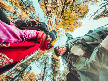 Low angle portrait of people in park during autumn