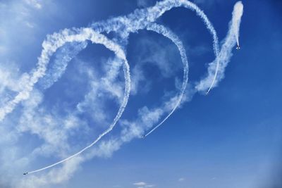 Low angle view of airshow against sky