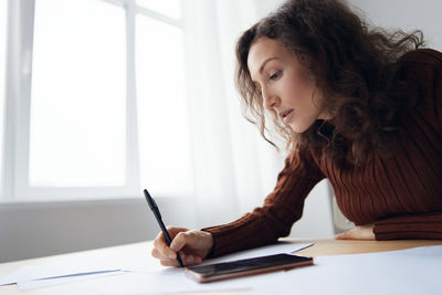 Young woman using laptop while sitting at home