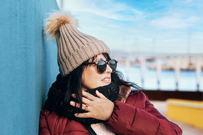 Portrait of young woman wearing sunglasses while standing against sky