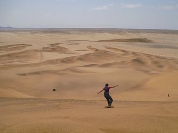 Full length of man on sand at beach against sky