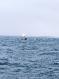 Sailboat sailing on sea against clear sky