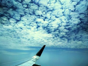 Airplane flying over cloudscape against sky