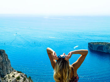 Rear view of woman in sea against sky