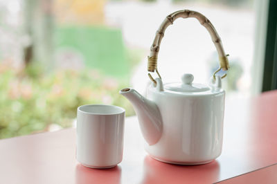 Close-up of teapot and cup on table