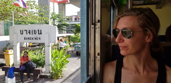 Portrait of woman wearing sunglasses with text