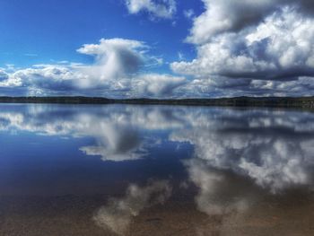 Scenic view of calm lake against cloudy sky