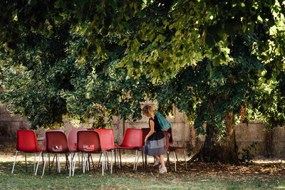 Side view of girl with chairs at park