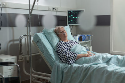 Woman lying on bed at hospital