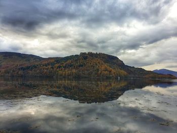 Scenic view of lake by mountain against sky