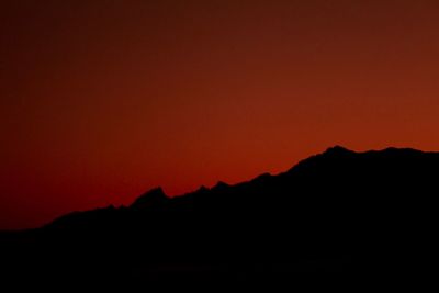 Silhouette mountains against clear sky during sunset