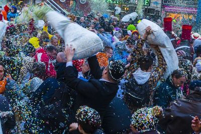 Crowd throwing colorful confetti in city during celebration