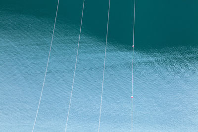 High angle view of power lines against sea water