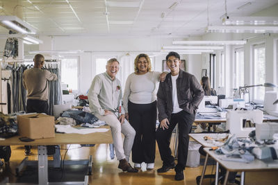 Portrait of happy multiracial fashion designers at workshop