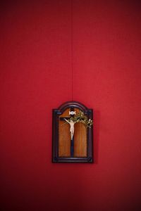 Low angle view of cross on red door