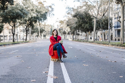 Portrait of woman with umbrella on road