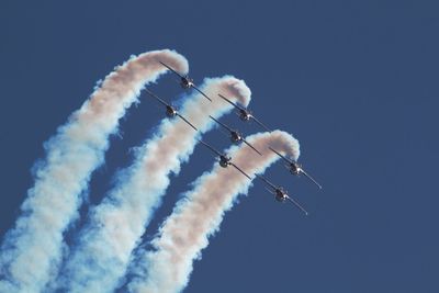 Low angle view of airshow against sky