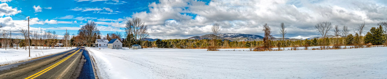 Panoramic view of trees and snowcapped mountains against sky