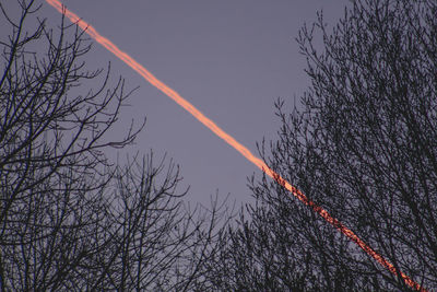 Low angle view of vapor trail in sky at dusk