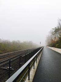Bridge in foggy weather against sky during winter