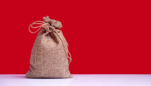 Close-up of hat on table against red background