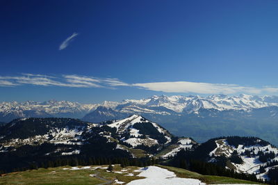 Scenic view of snowcapped mountains against clear blue sky