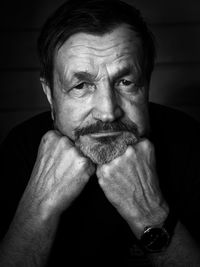 Portrait of man with hand on chin in darkroom