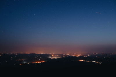 Illuminated city against sky at night