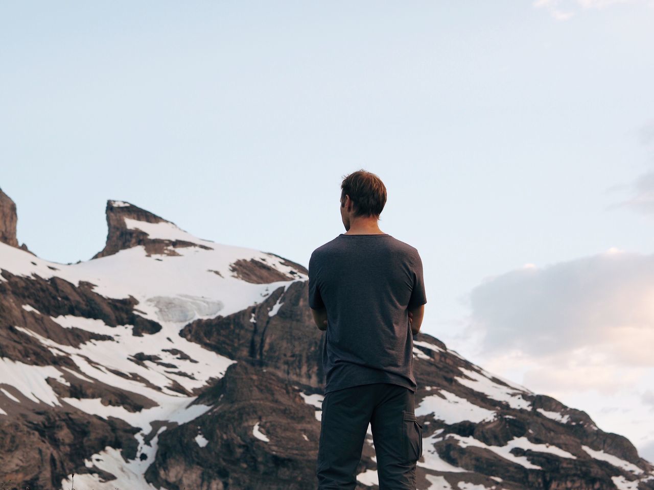 rear view, snow, cold temperature, winter, mountain, beauty in nature, leisure activity, standing, tranquil scene, men, scenics, tranquility, lifestyles, three quarter length, nature, remote, physical geography, tourist, sky, mountain range, vacations, non-urban scene, majestic, tourism, getting away from it all, day