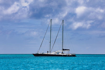 Sailboat sailing on sea against sky