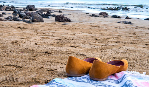 Close-up of shoes on beach