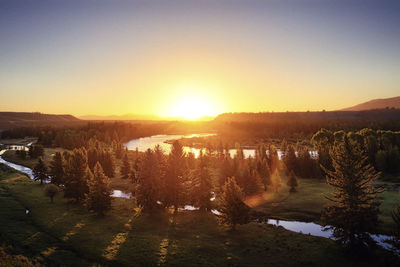 Scenic view of river against clear sky during sunset