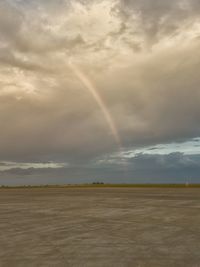Scenic view of rainbow over land against sky