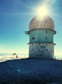 Lighthouse by sea against sky