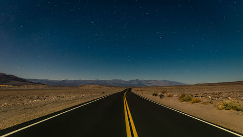 Scenic view of road against clear sky at night