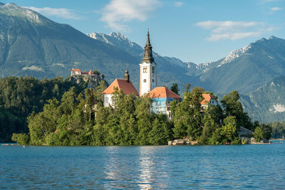 Scenic view of lake by buildings against sky