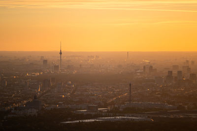 Aerial view of buildings in city during sunset