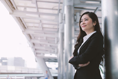 Confident businesswoman with arms crossed looking away