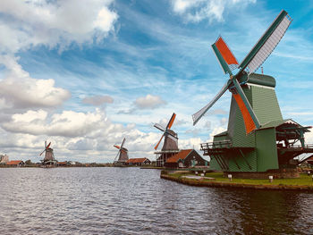 Traditional windmill on shore against sky