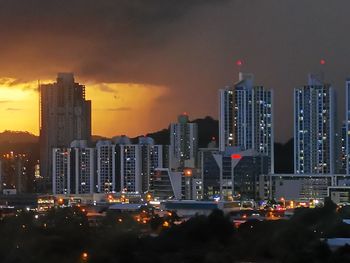 Illuminated buildings in city against sky at night