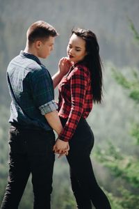 Loving young couple standing in forest