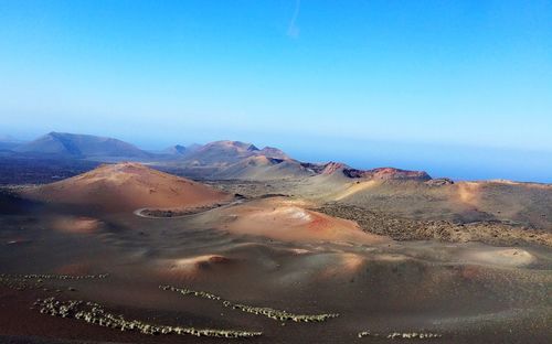 Scenic view of desert against clear blue sky