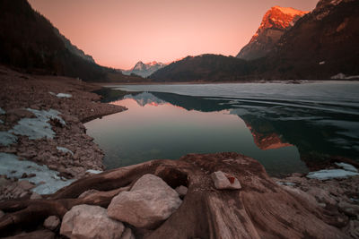 Scenic view of lake by mountains against sky