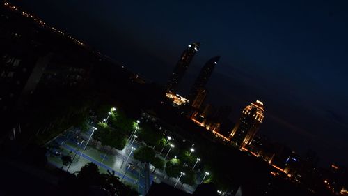 Illuminated cityscape against sky at night