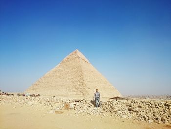 Man standing by pyramid against clear sky