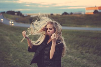 Young woman with long hair standing on field