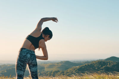 Full length of woman standing on field against clear sky