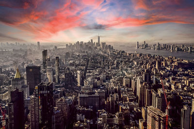 Aerial view of city against cloudy sky during sunset