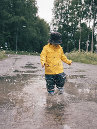 Toddler splashing in puddle