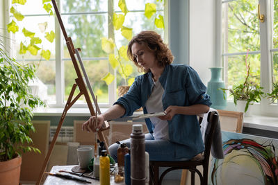 Artist taking paint from jar